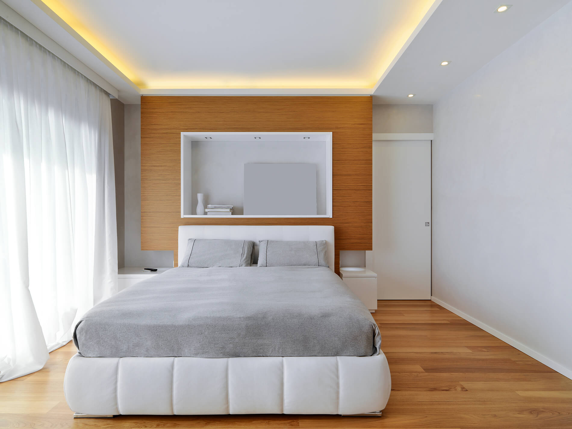 Controsoffitto in cartongesso con strisce LED perimetrali in un soggiorno moderno.