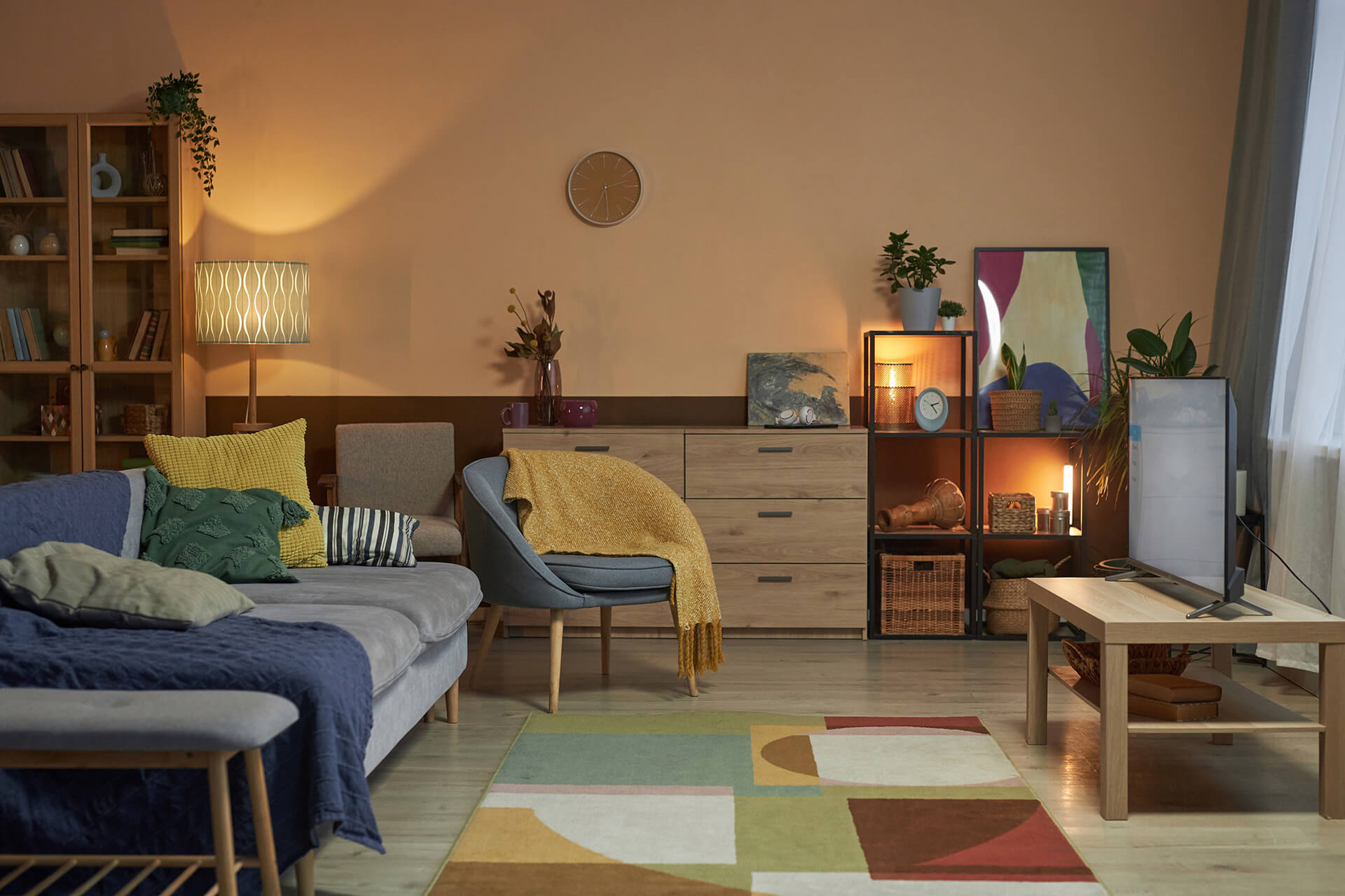 Soggiorno accogliente con palette di colori caldi, divano in tessuto naturale e illuminazione stratificata
