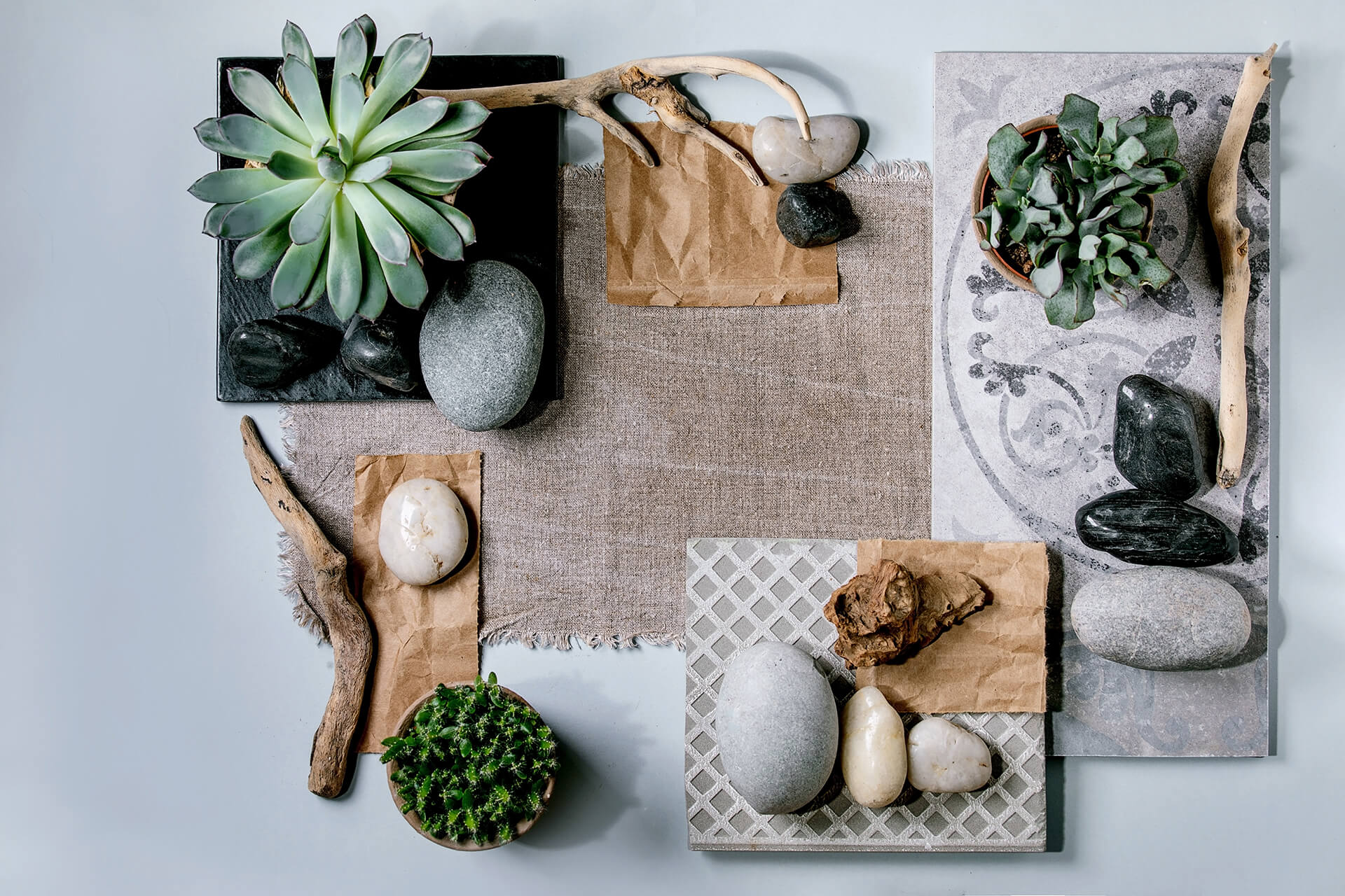 Moodboard fisica per interior design con campioni materiale, legno e pietre ed elementi naturali utilizzata per definire lo stile di un progetto.